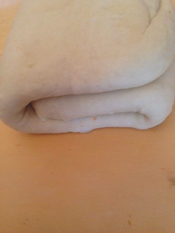 Iniziate nuovamente a stendere la sfoglia con il matterello sempre prestando attenzione e usando delicatezza. Avvolgete l'impasto al matterello e stendetelo in maniera tale che possiate stenderlo anche dal lato che prima toccava la spianatoia.