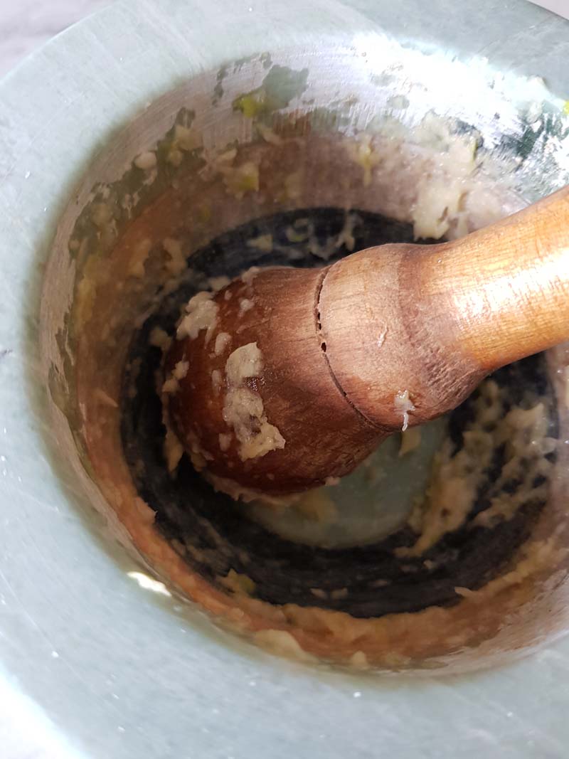 Usa il pestello e inizia a lavorare il pesto