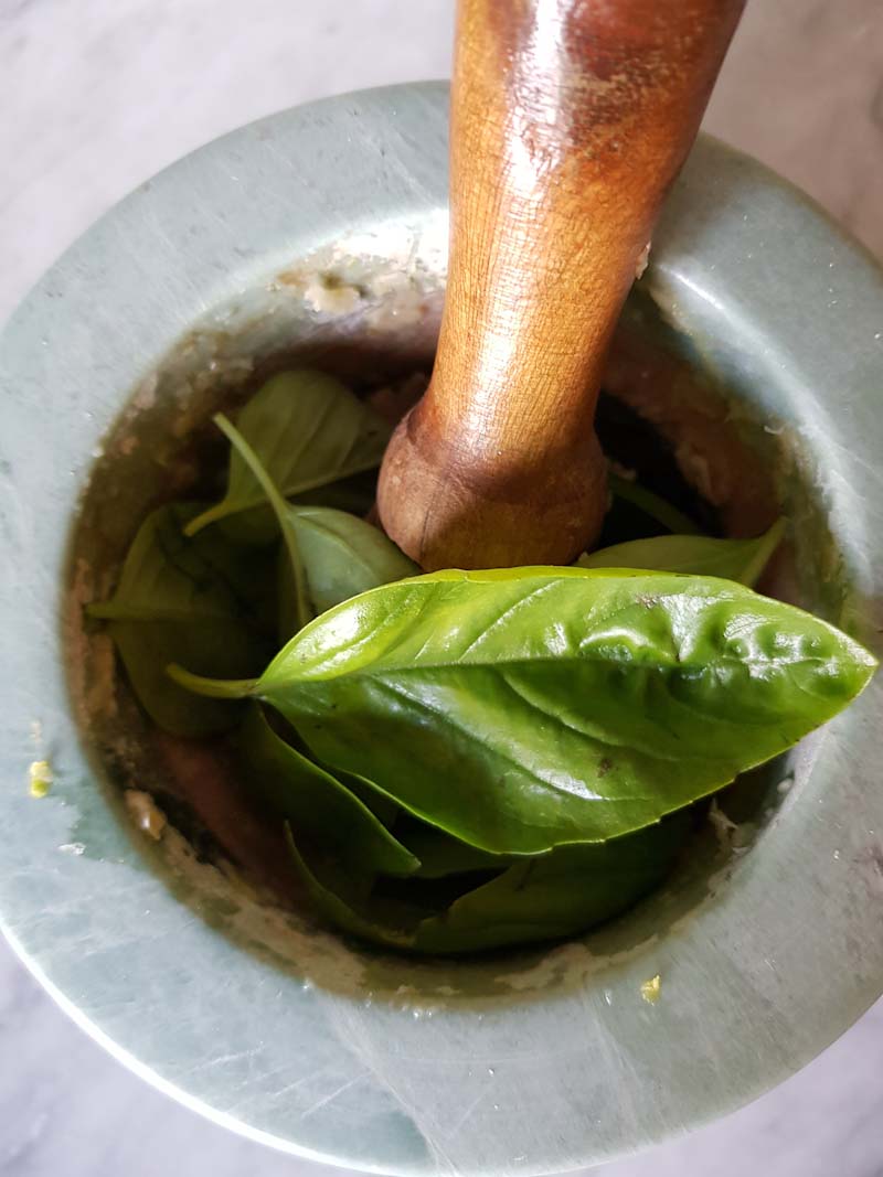 inserisci le foglie di basilico e lavorale nel mortaio